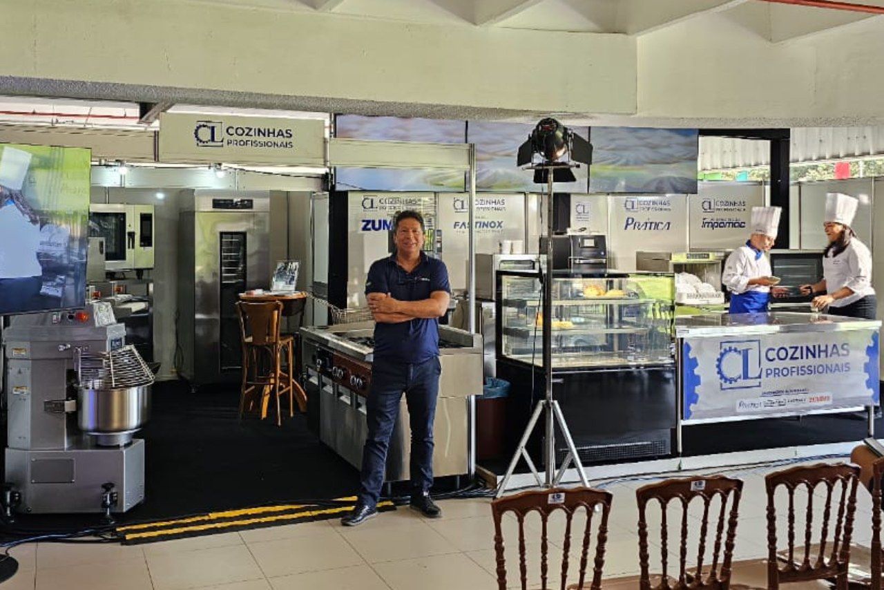 Um homem está de pé em um restaurante com os braços cruzados.