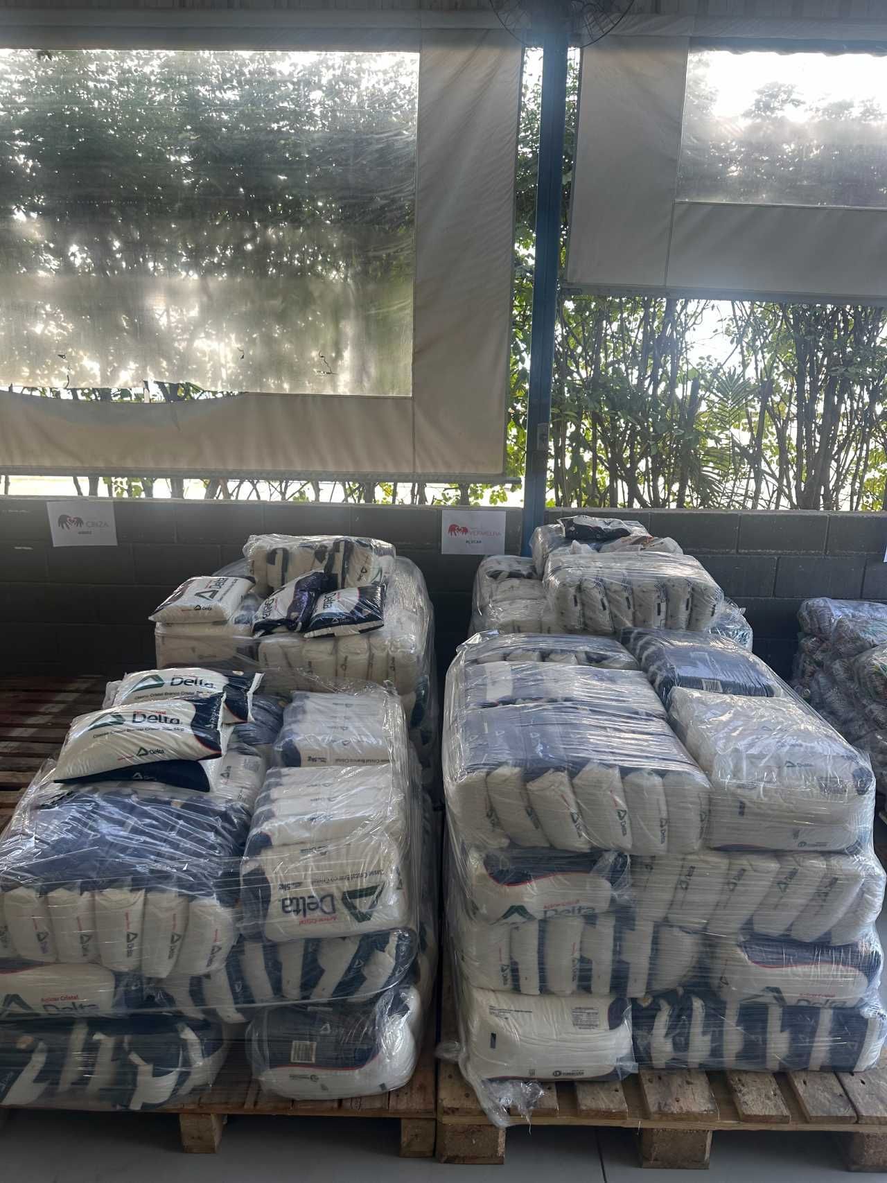 Um monte de sacos empilhados uns sobre os outros em paletes.