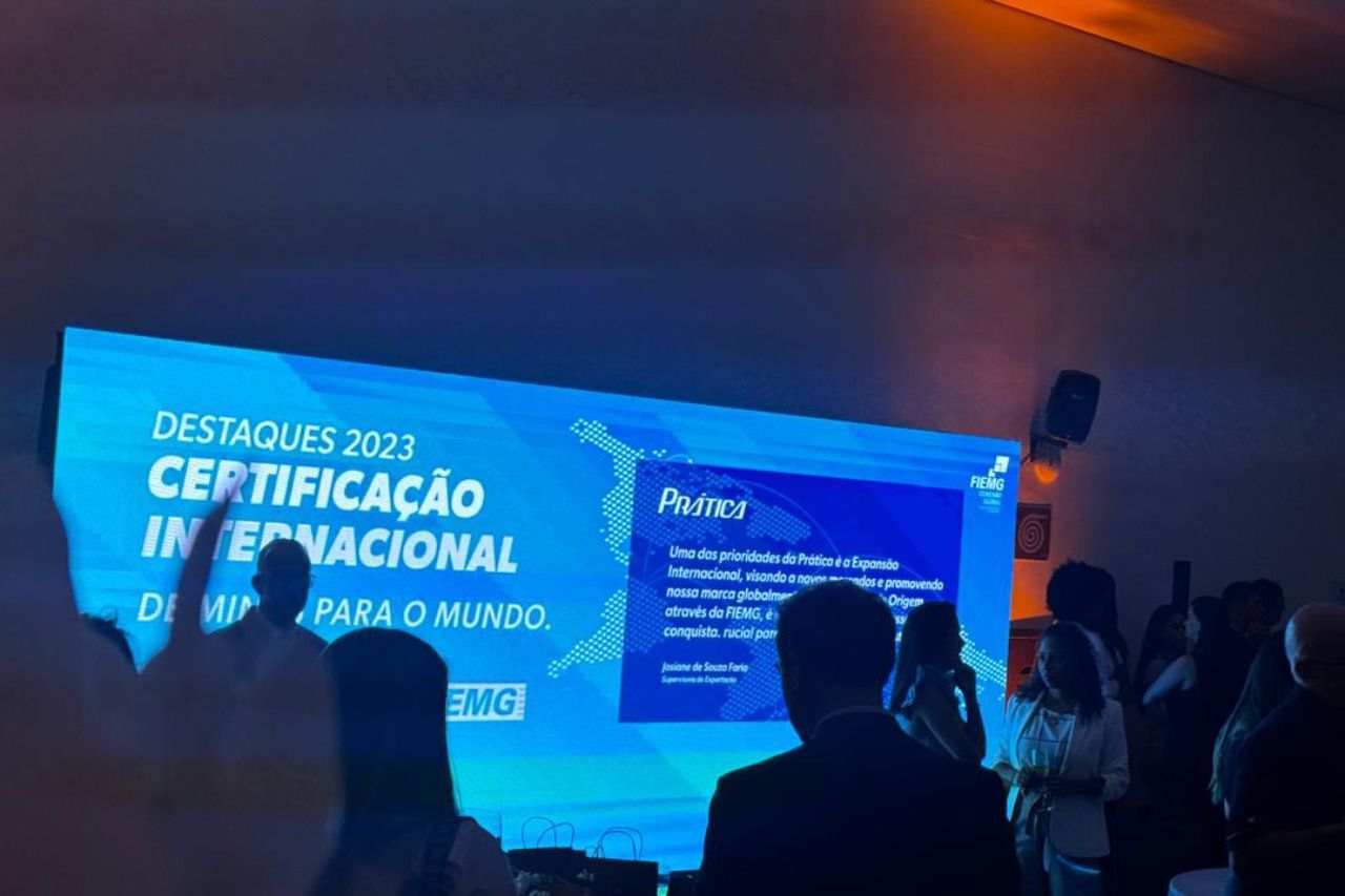 Um grupo de pessoas em pé em frente a uma tela que diz destaques 2013