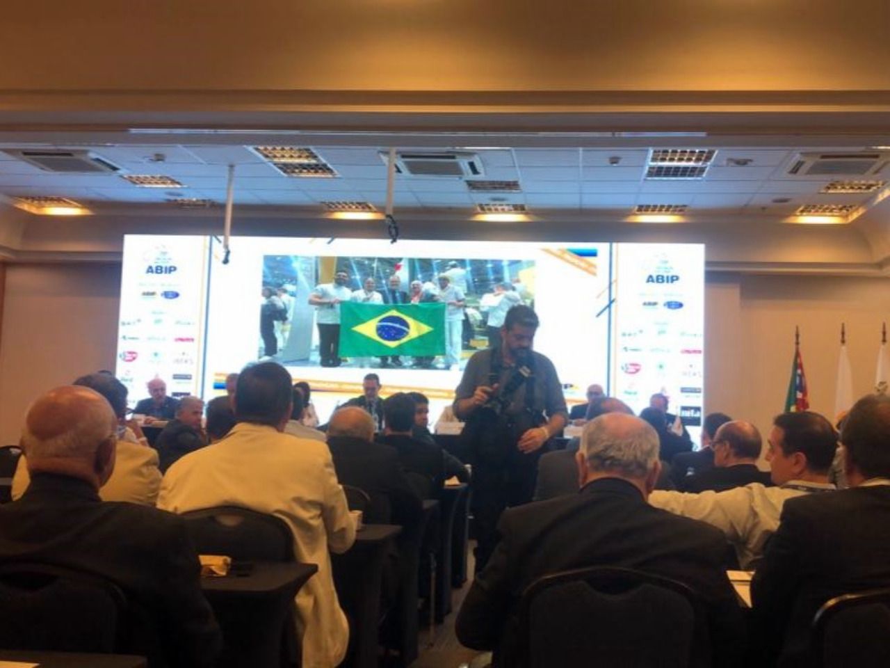 Um homem está fazendo uma apresentação para um grupo de pessoas em uma sala de conferências.