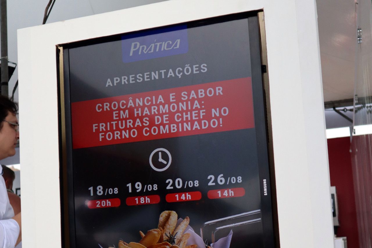 Um homem está na frente de uma placa que diz 'fala'