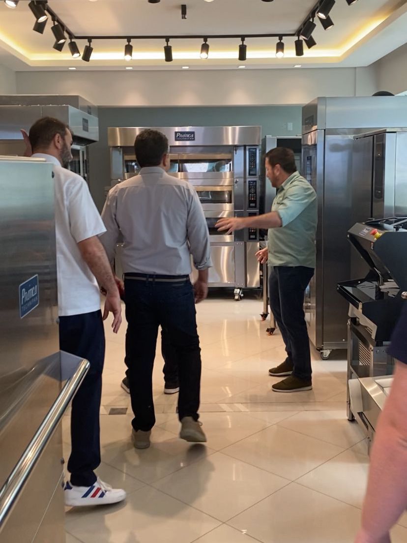 Um grupo de homens está em uma cozinha conversando entre si