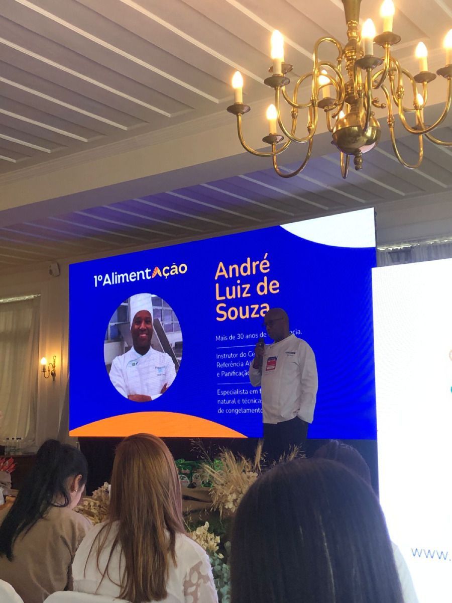 Pessoas sentadas em frente a uma tela que diz andre luiz de souza