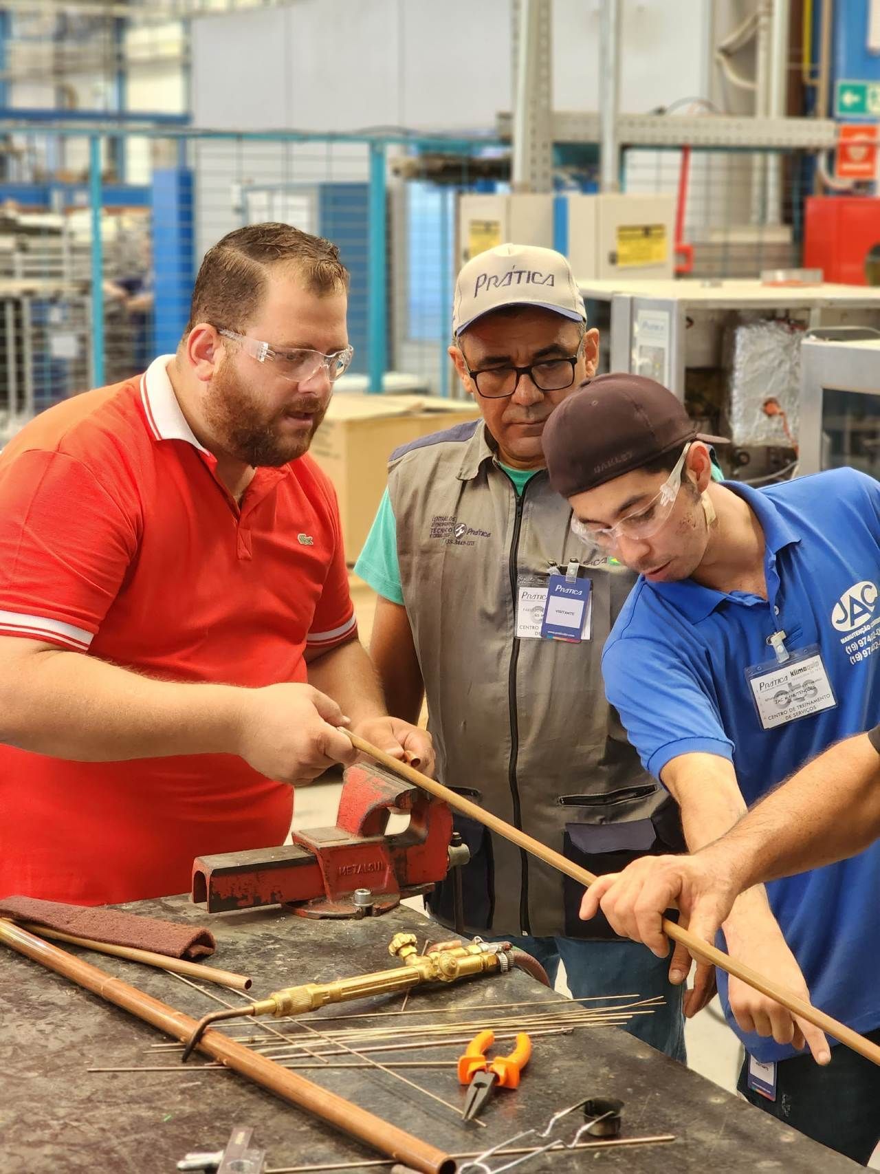Um grupo de homens está trabalhando em canos em uma fábrica.
