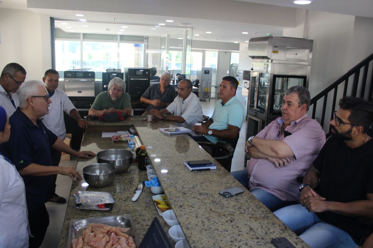 Um grupo de homens está sentado ao redor de uma mesa em um restaurante.