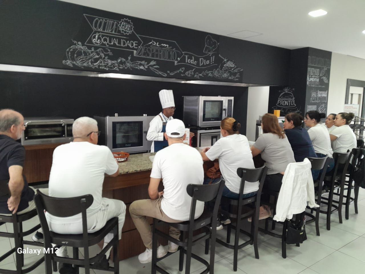 Um grupo de pessoas está sentado no balcão de um restaurante.