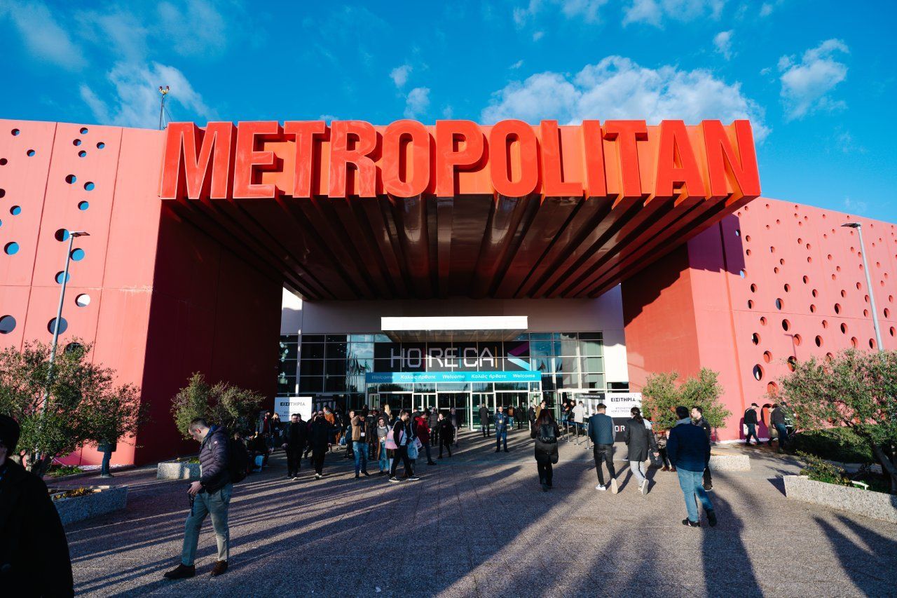 As pessoas estão caminhando em frente a um prédio que diz metropolitano