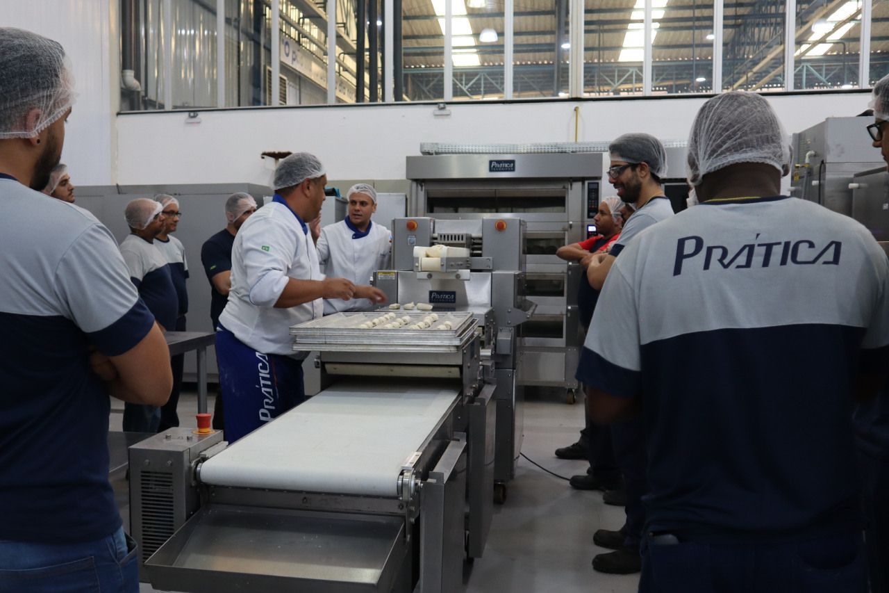 Um homem vestindo uma camisa que diz prática está trabalhando em uma padaria