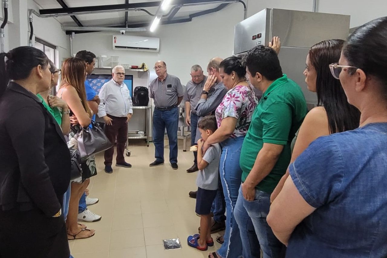 Um grupo de pessoas está em uma sala conversando entre si.
