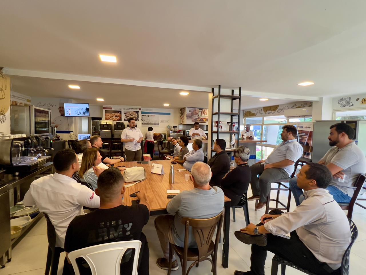 Um grupo de pessoas está sentado ao redor de uma mesa em um restaurante.