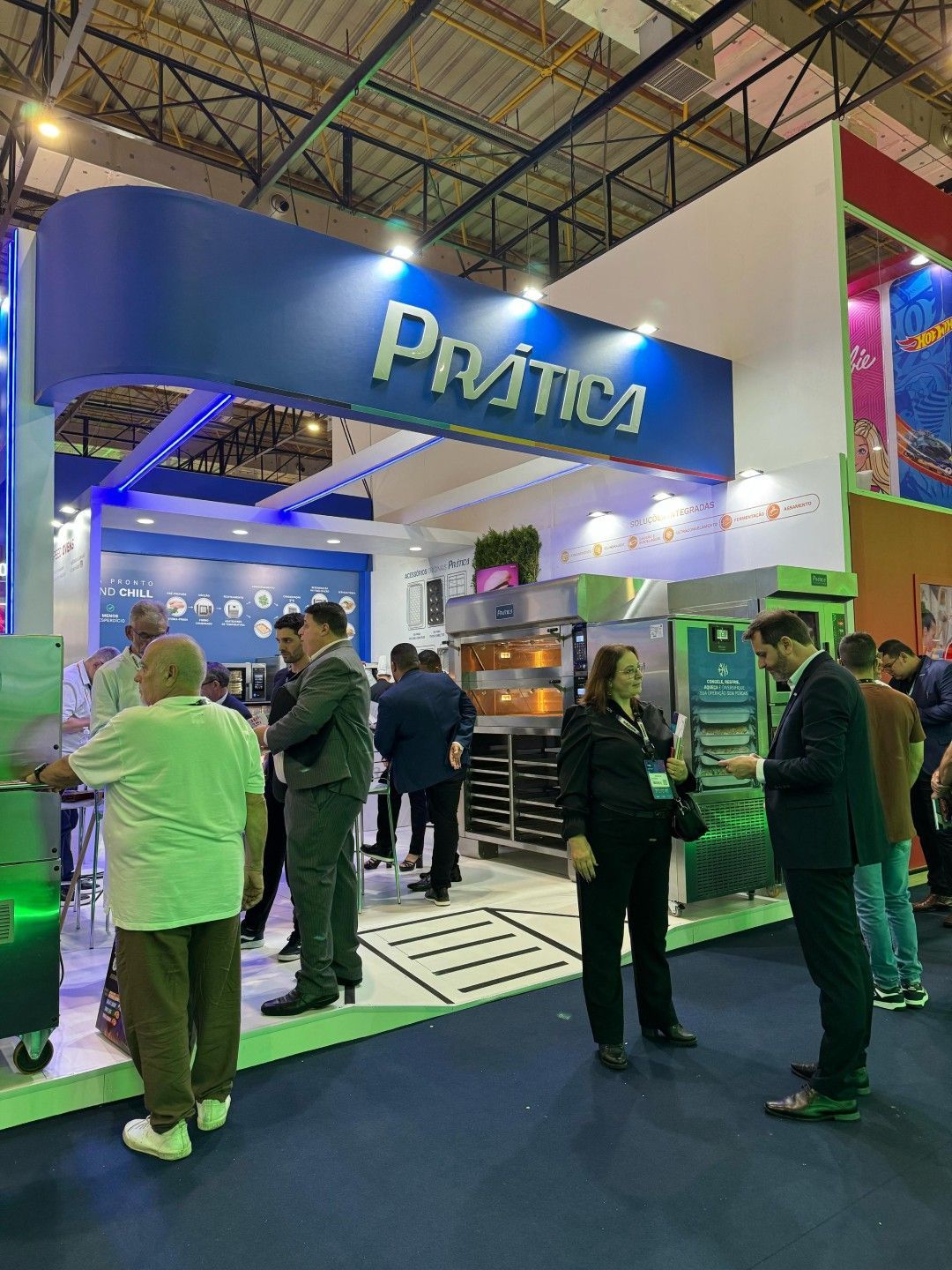 Um grupo de pessoas está em volta de um estande em uma convenção.