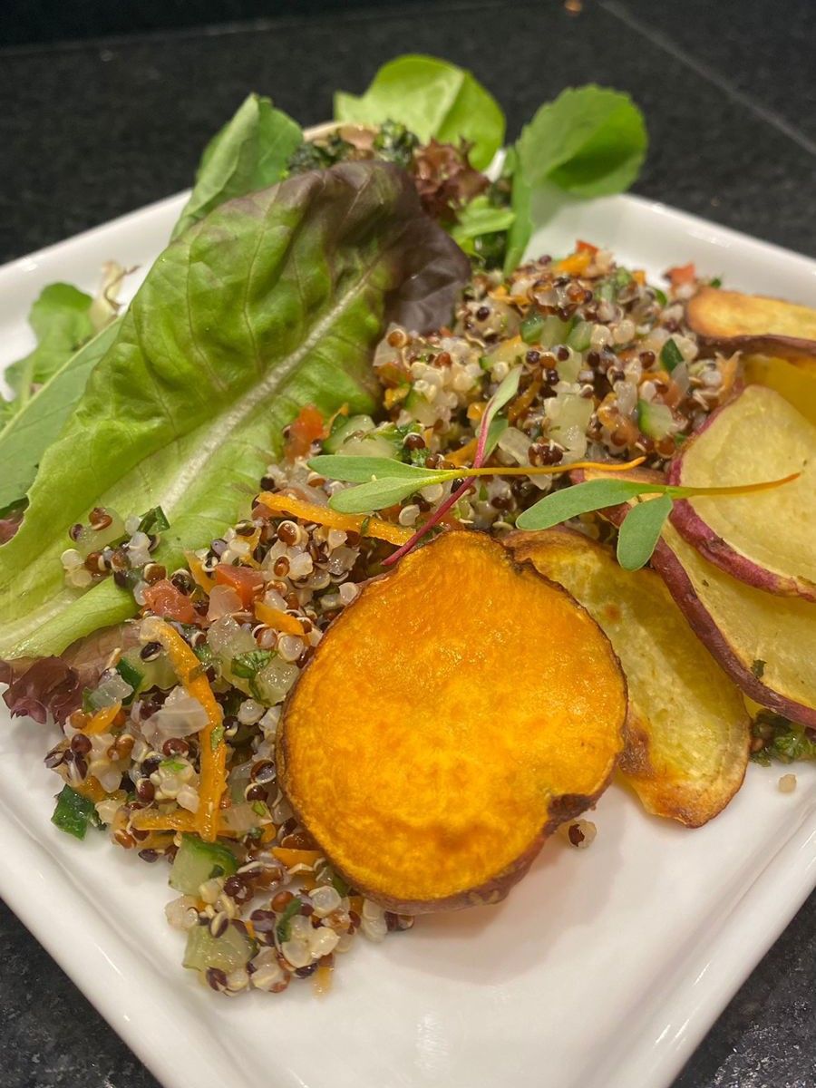 Um prato branco coberto com salada, batata-doce e alface.