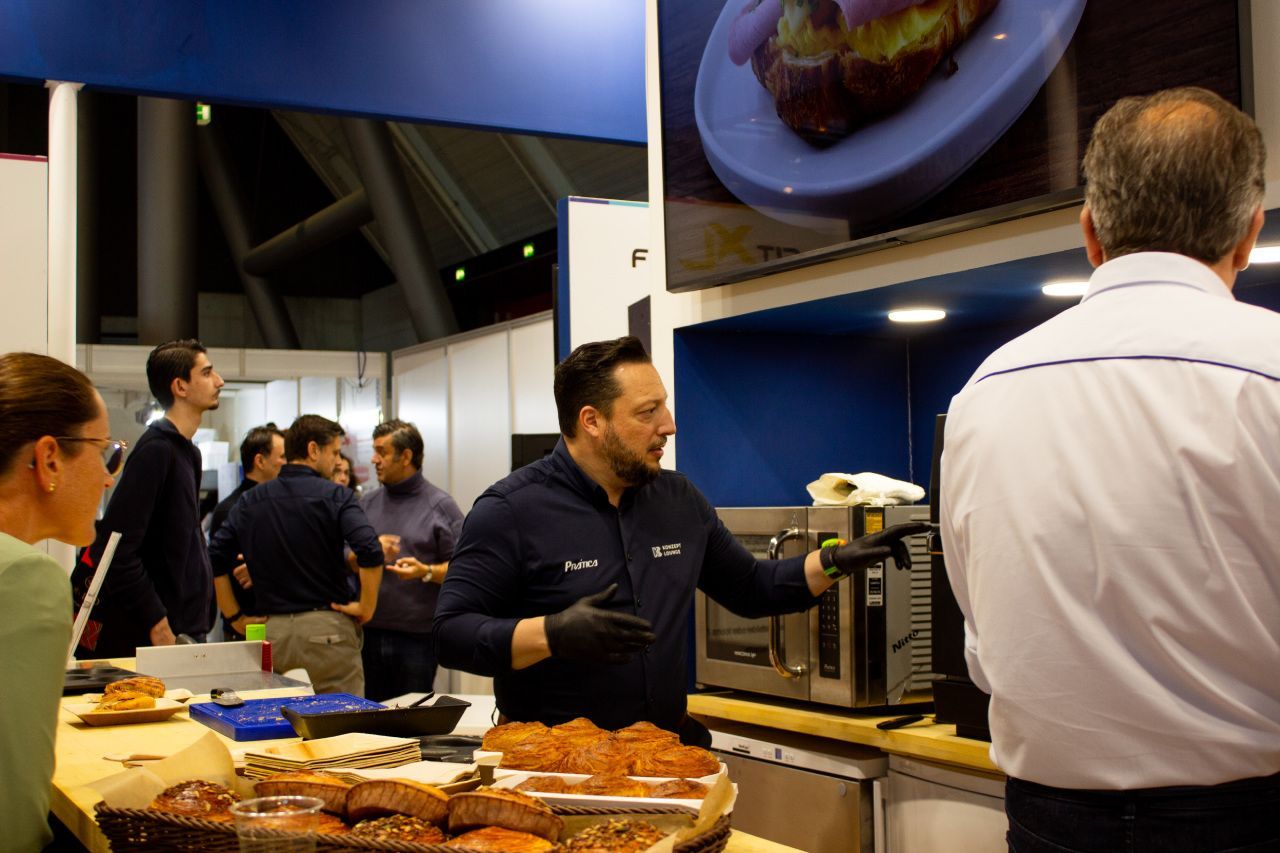 Um homem está servindo comida para um grupo de pessoas em um restaurante.