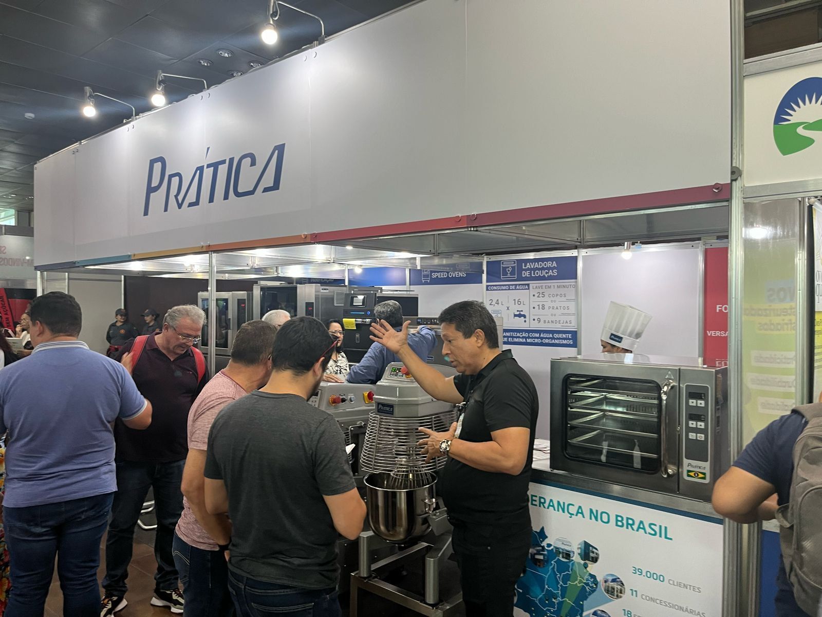 Um grupo de pessoas está em volta de um estande em uma convenção.