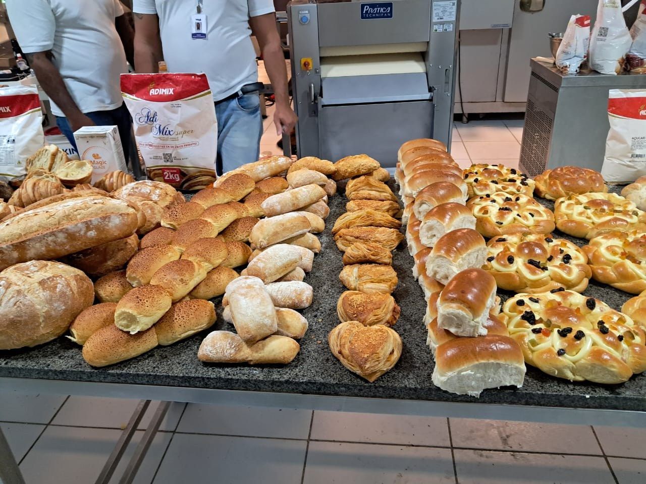 Um monte de pão está sobre uma mesa em uma padaria.