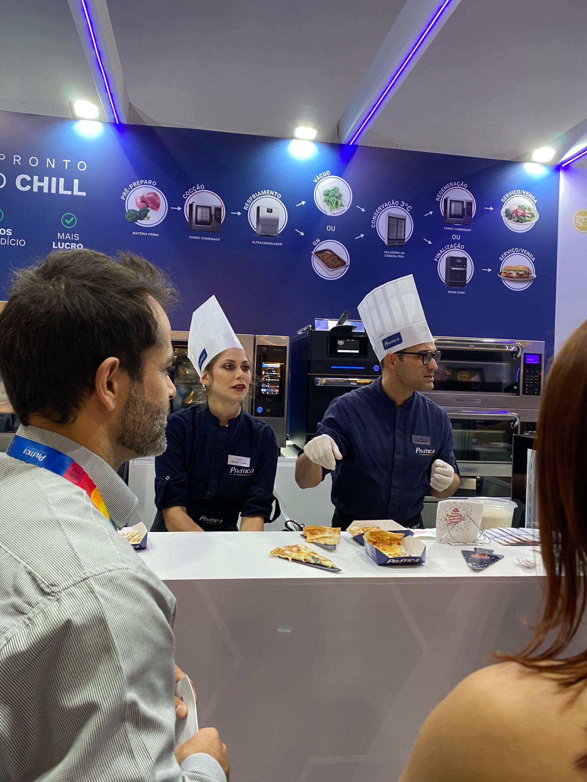 Um grupo de pessoas está sentado em uma mesa em frente a uma parede que diz relaxe