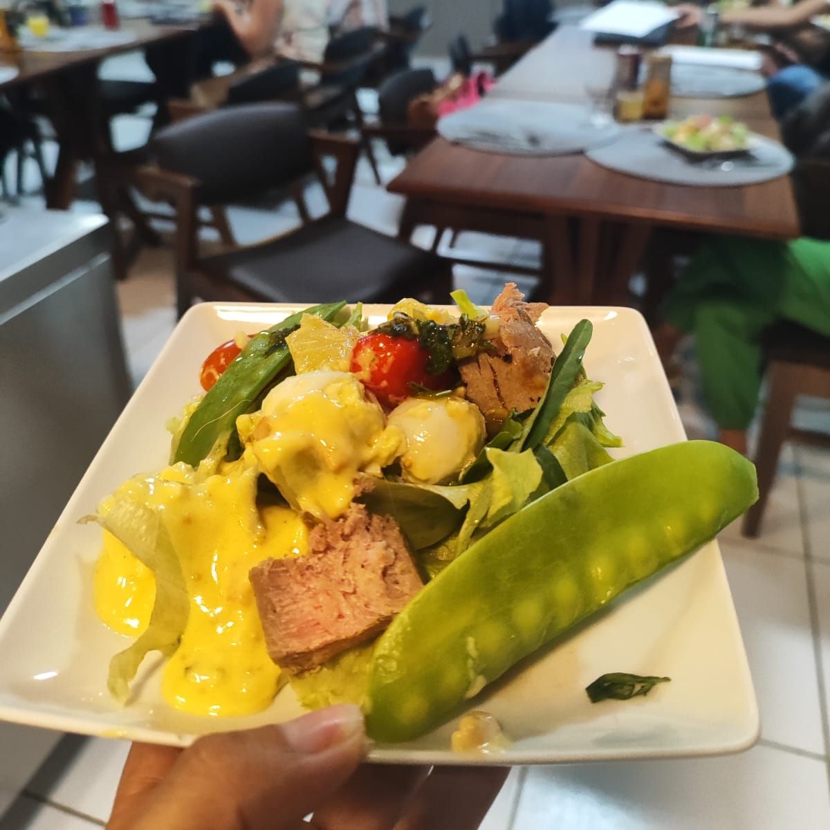 Uma pessoa está segurando um prato de comida na mão