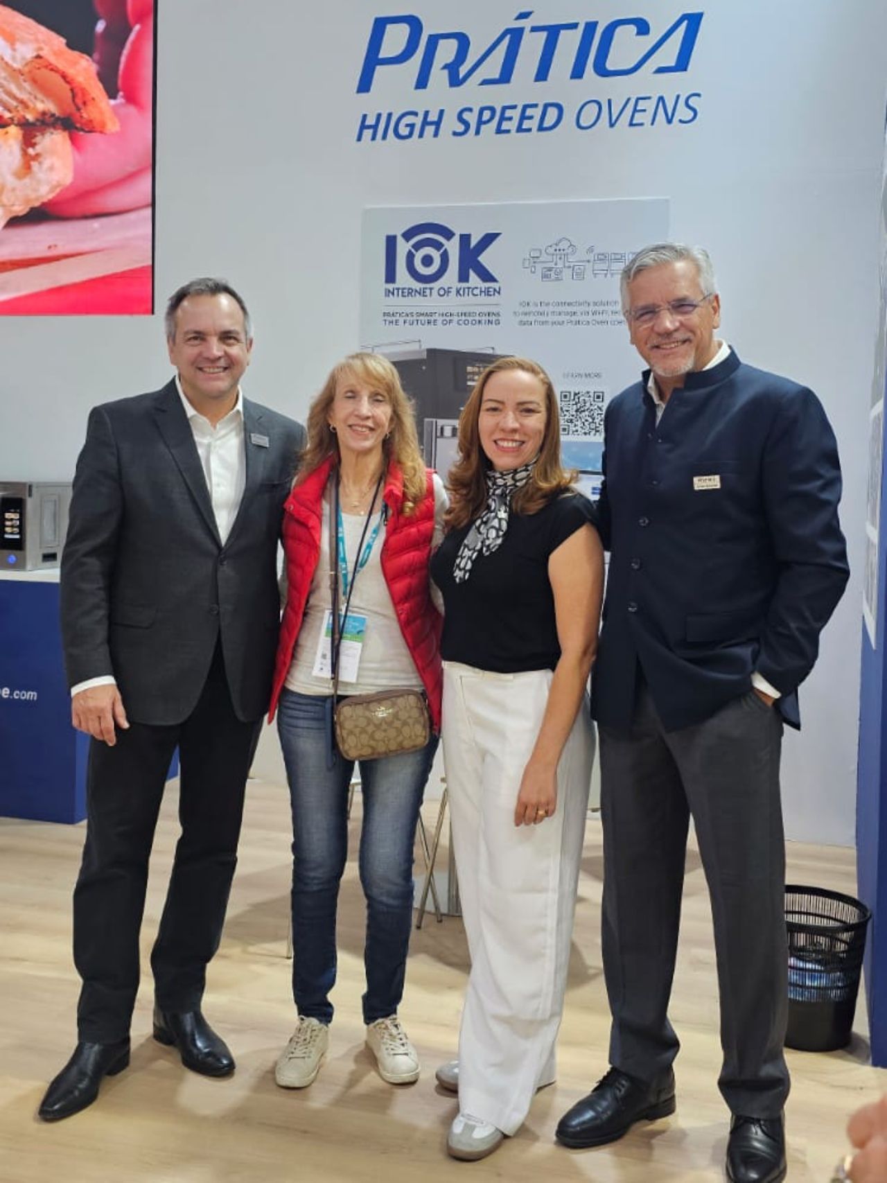 Quatro pessoas em frente a uma placa “Fornos de Alta Velocidade Prática”.