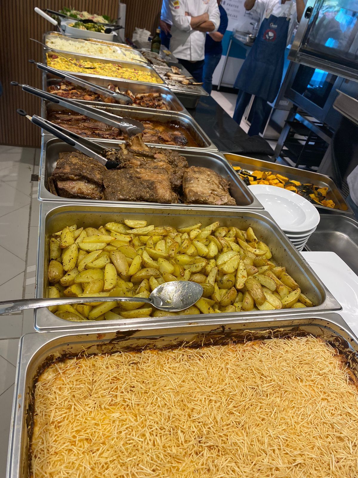 Uma mesa de bufê cheia de muitos tipos diferentes de comida.