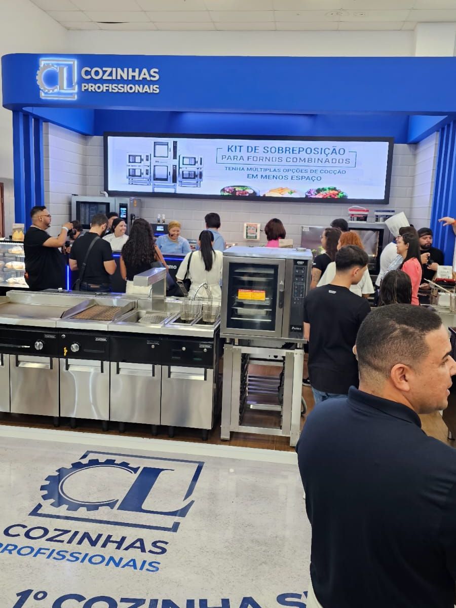 Um grupo de pessoas está em frente a uma placa que diz cozinhas profissionais