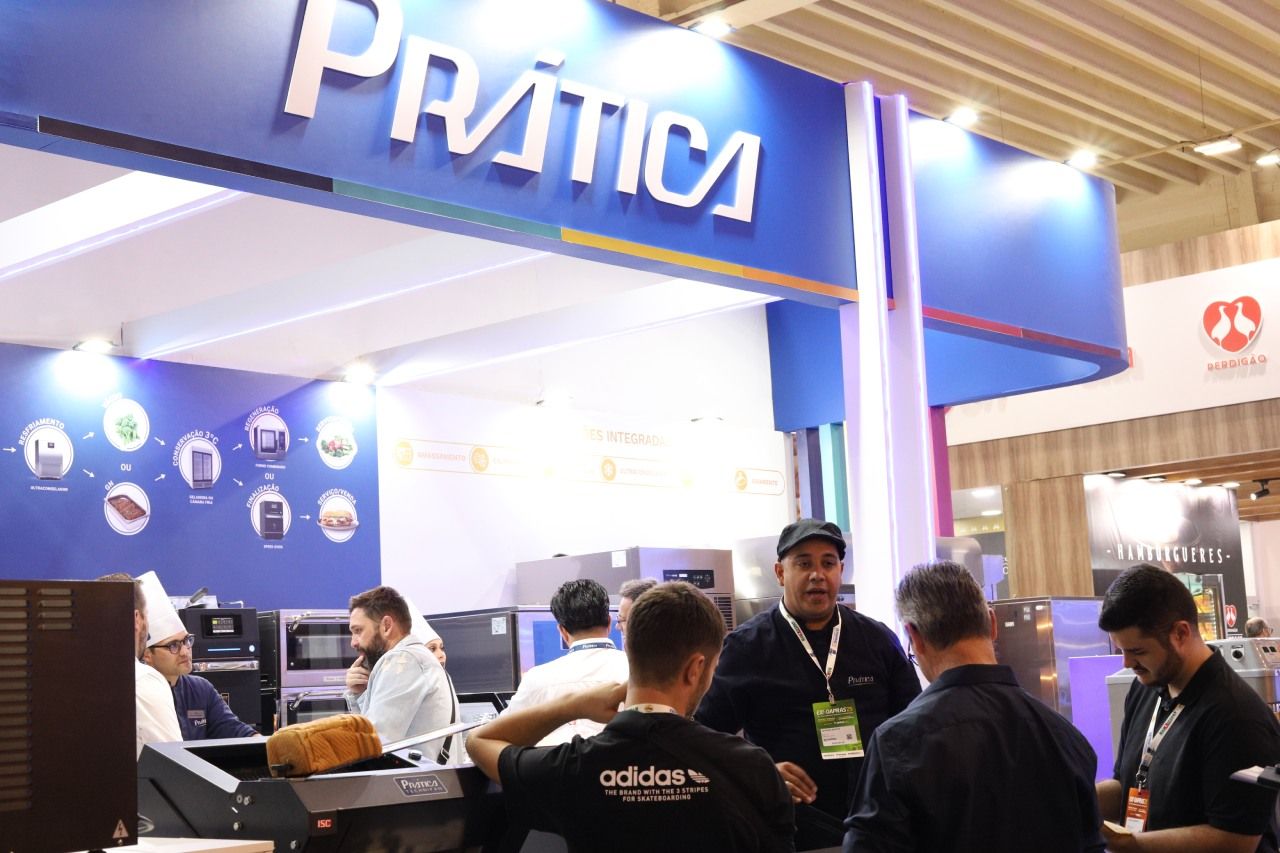 Um grupo de pessoas está parado sob uma placa que diz pratica