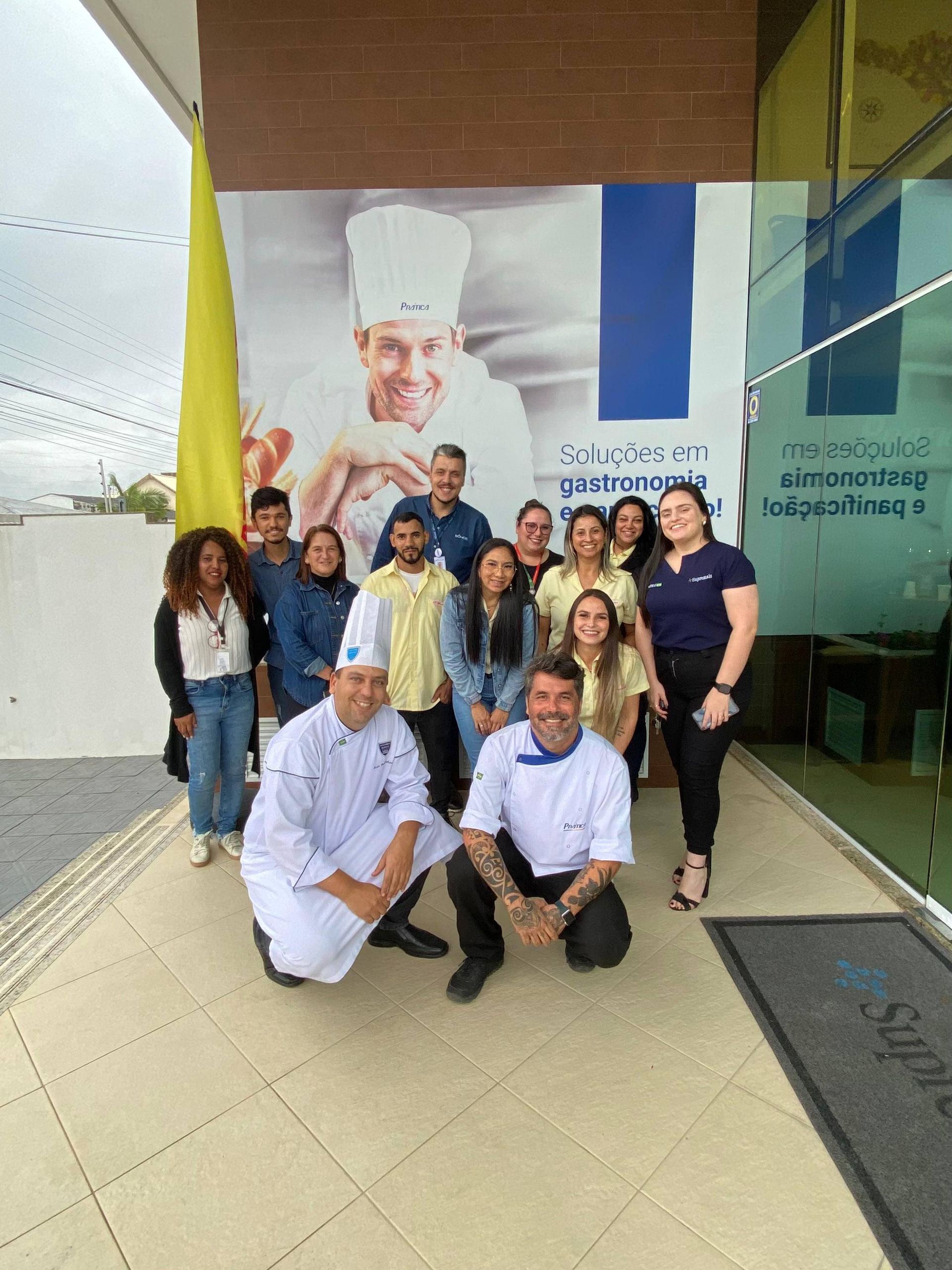 Um grupo de pessoas posando para uma foto em frente a um prédio