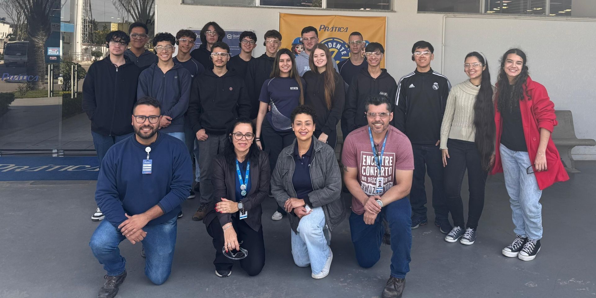 Um grupo de alunos e professores posando ao ar livre. Alguns ajoelhados na primeira fila.