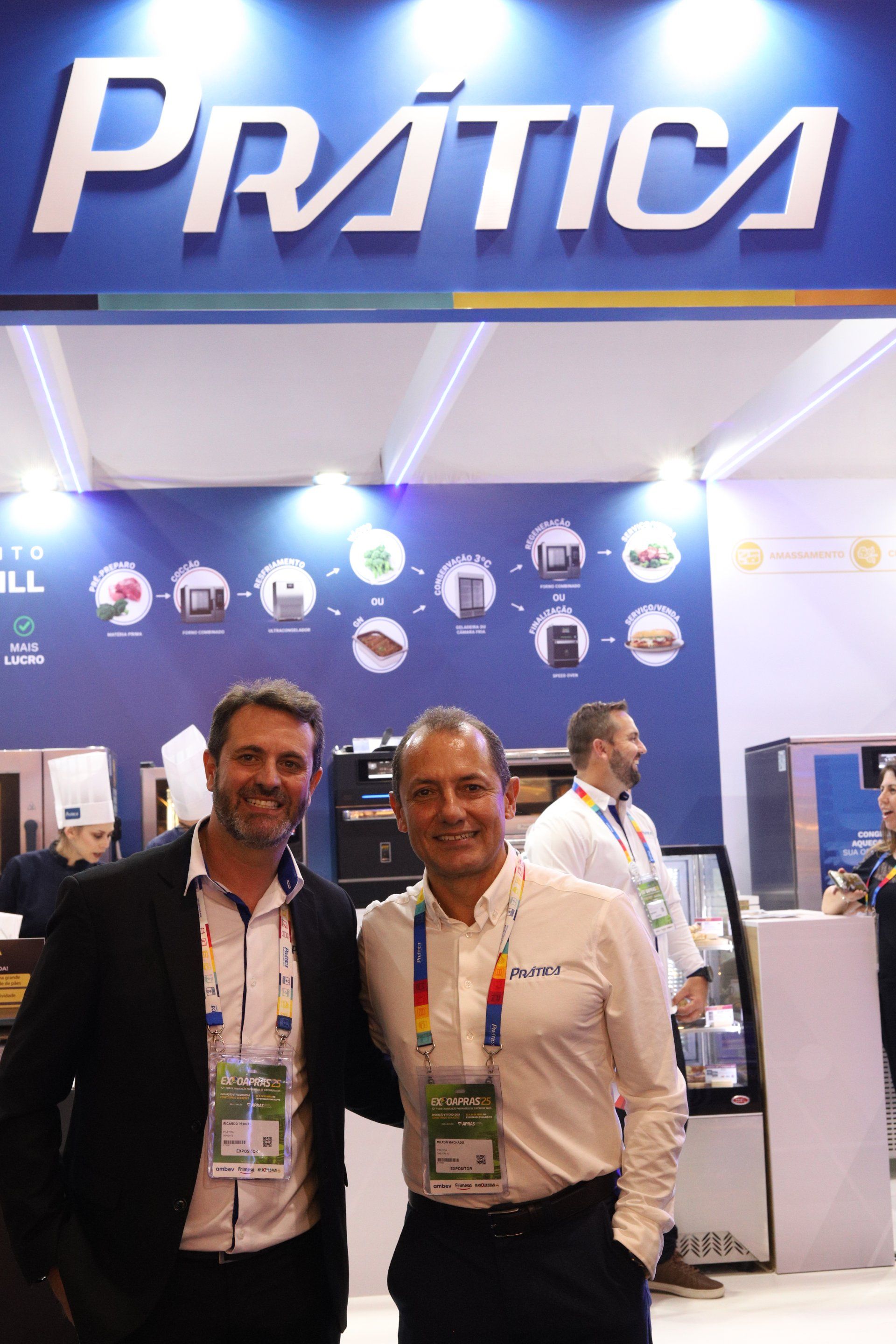 Dois homens estão posando para uma foto em frente a uma placa de prática