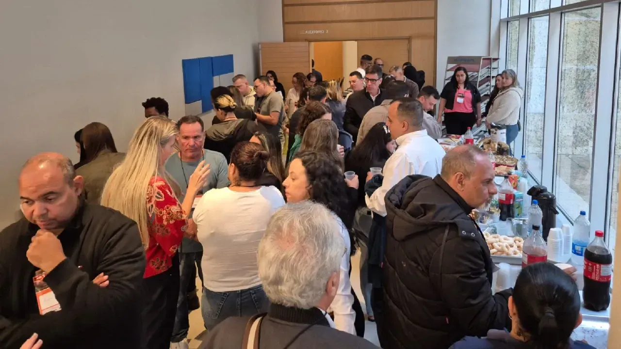 Um grande grupo de pessoas está em uma sala.