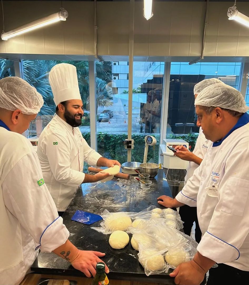 Um grupo de chefs está preparando comida em uma cozinha
