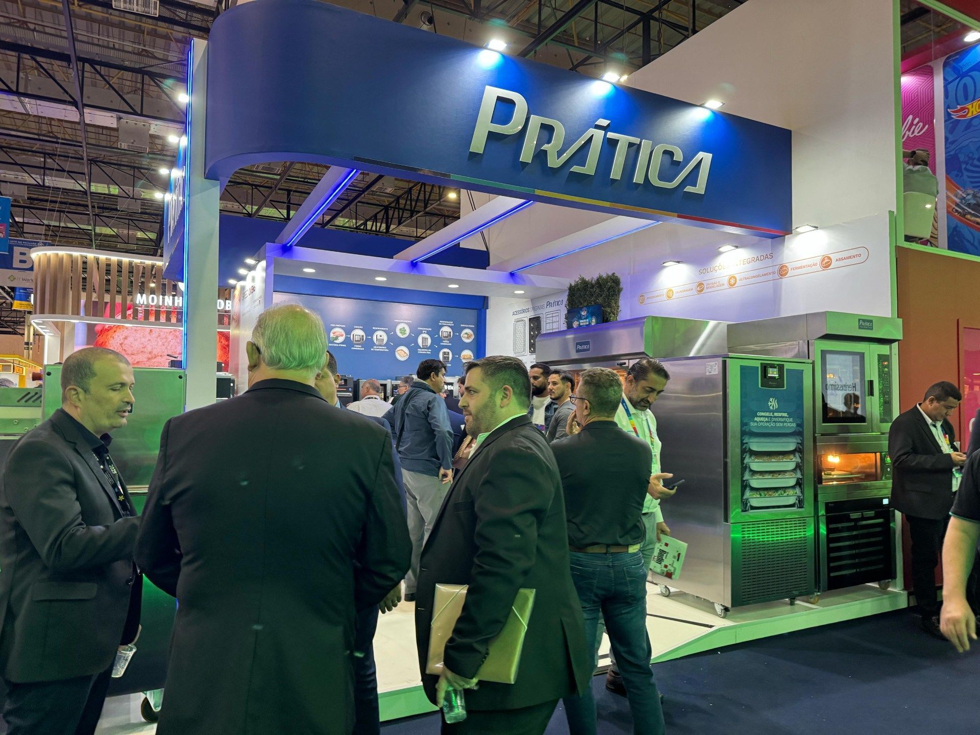 Um grupo de homens está em frente a um estande em uma convenção.