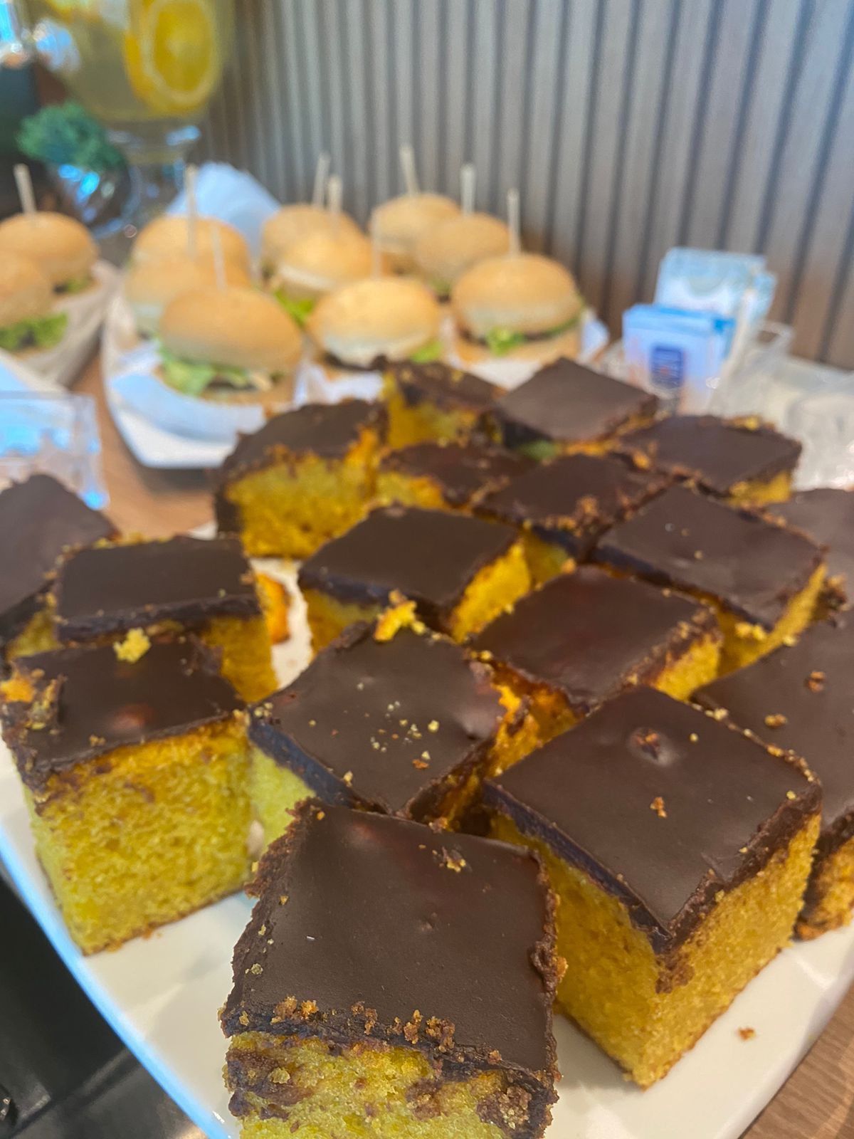 Um prato branco coberto com fatias de bolo de cenoura e cobertura de chocolate.