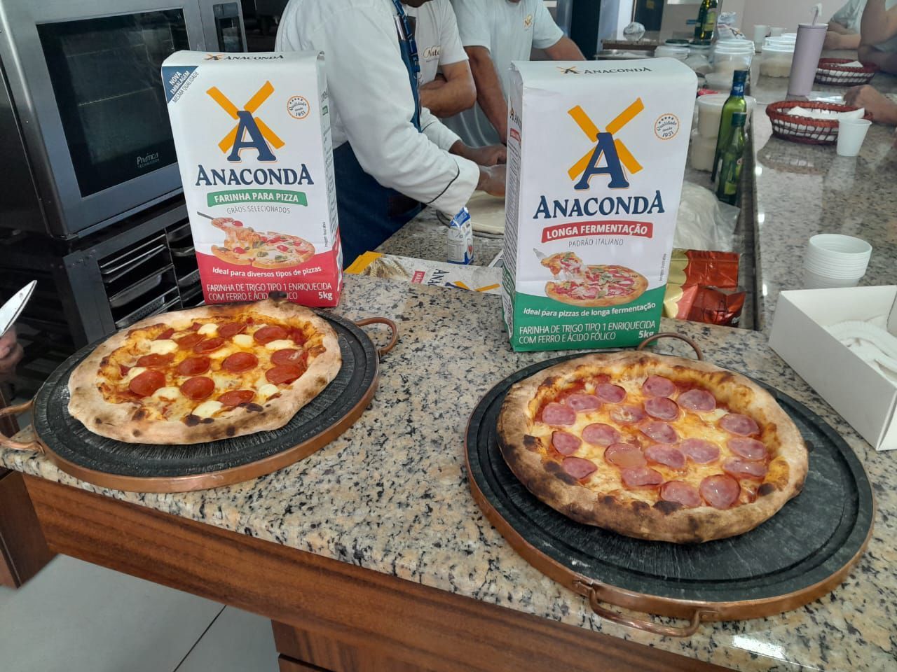 Duas pizzas estão em um balcão ao lado de duas caixas de anaconda