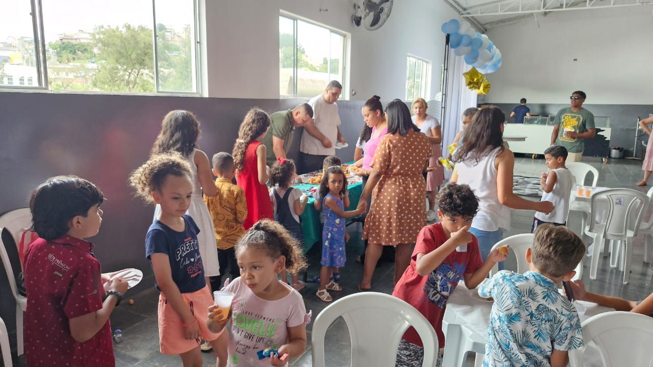 Um grupo de crianças está sentado em mesas em uma sala.