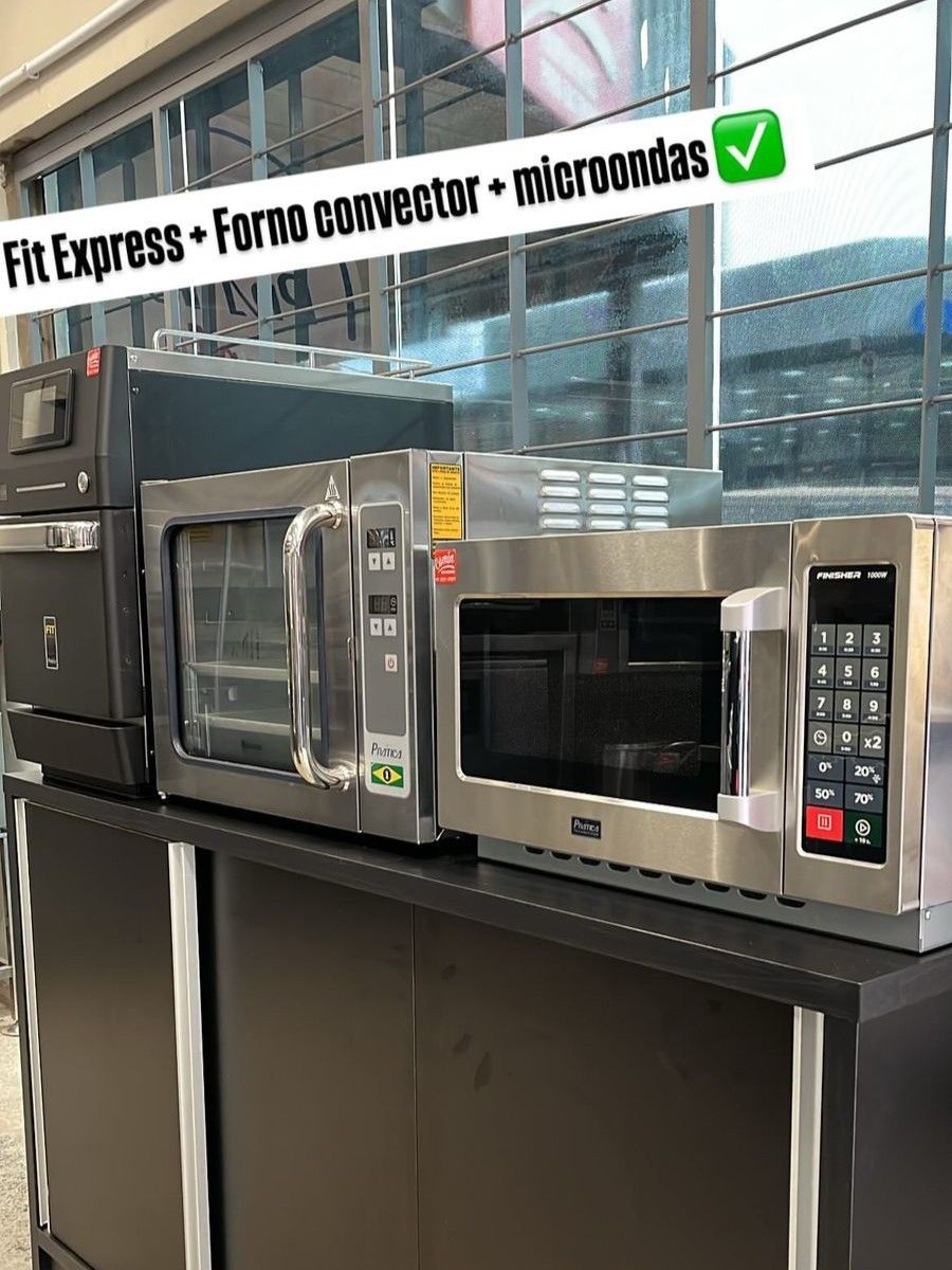 Uma fileira de fornos de micro-ondas estão alinhados em um balcão.