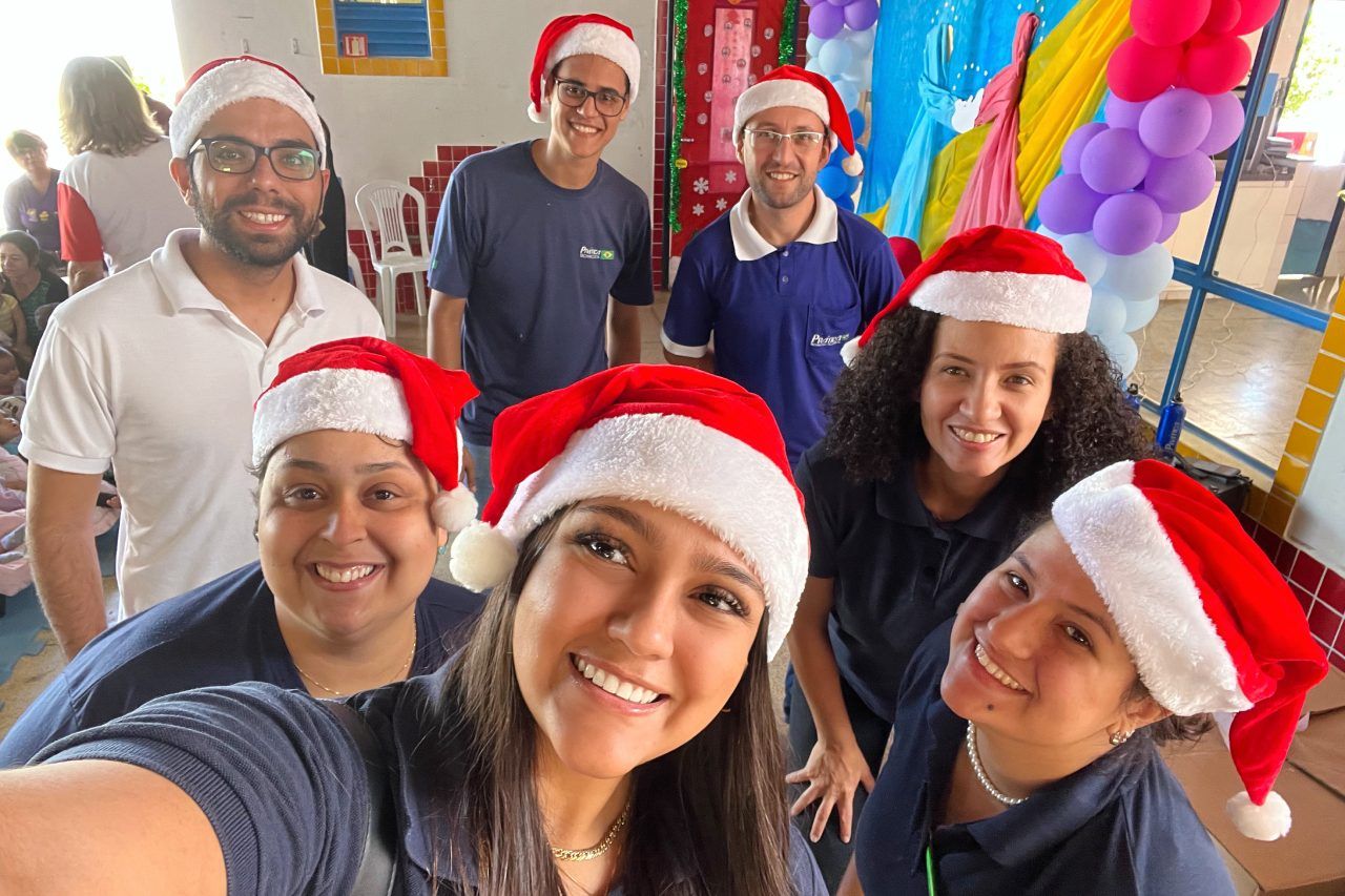 Um grupo de pessoas usando chapéus de Papai Noel está posando para uma foto.