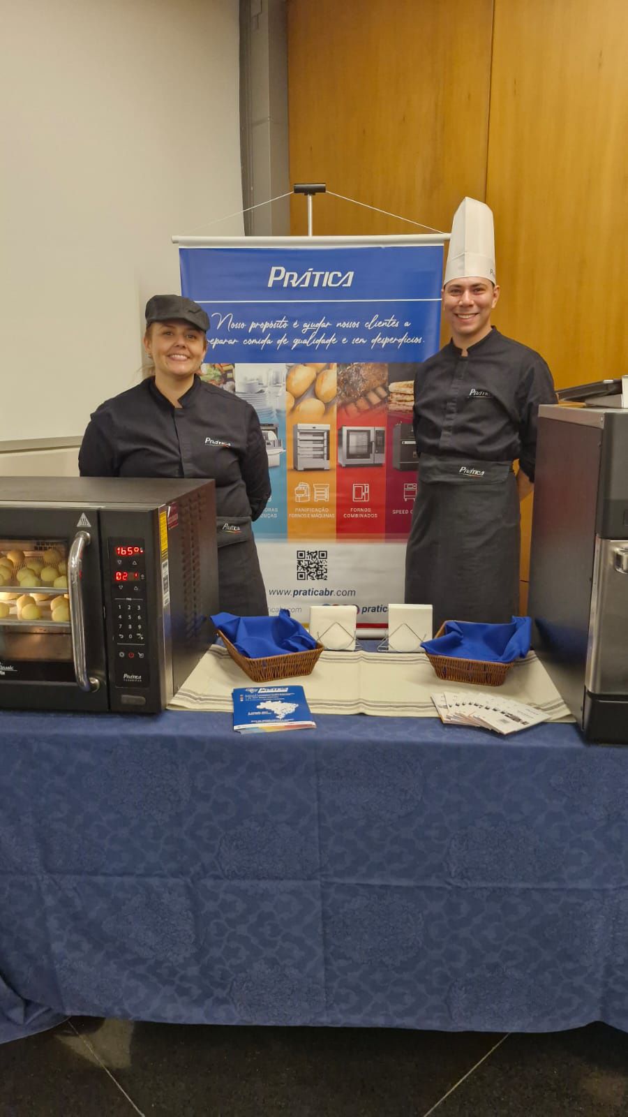 Um homem e uma mulher estão em pé em frente a uma mesa.