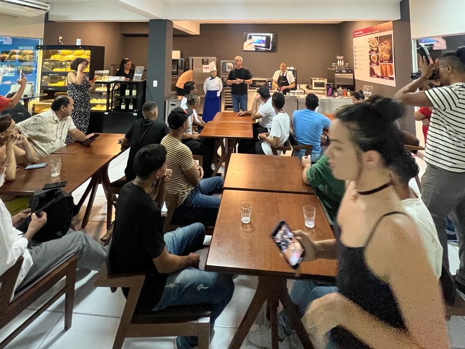 Um grupo de pessoas está sentado em mesas em um restaurante.