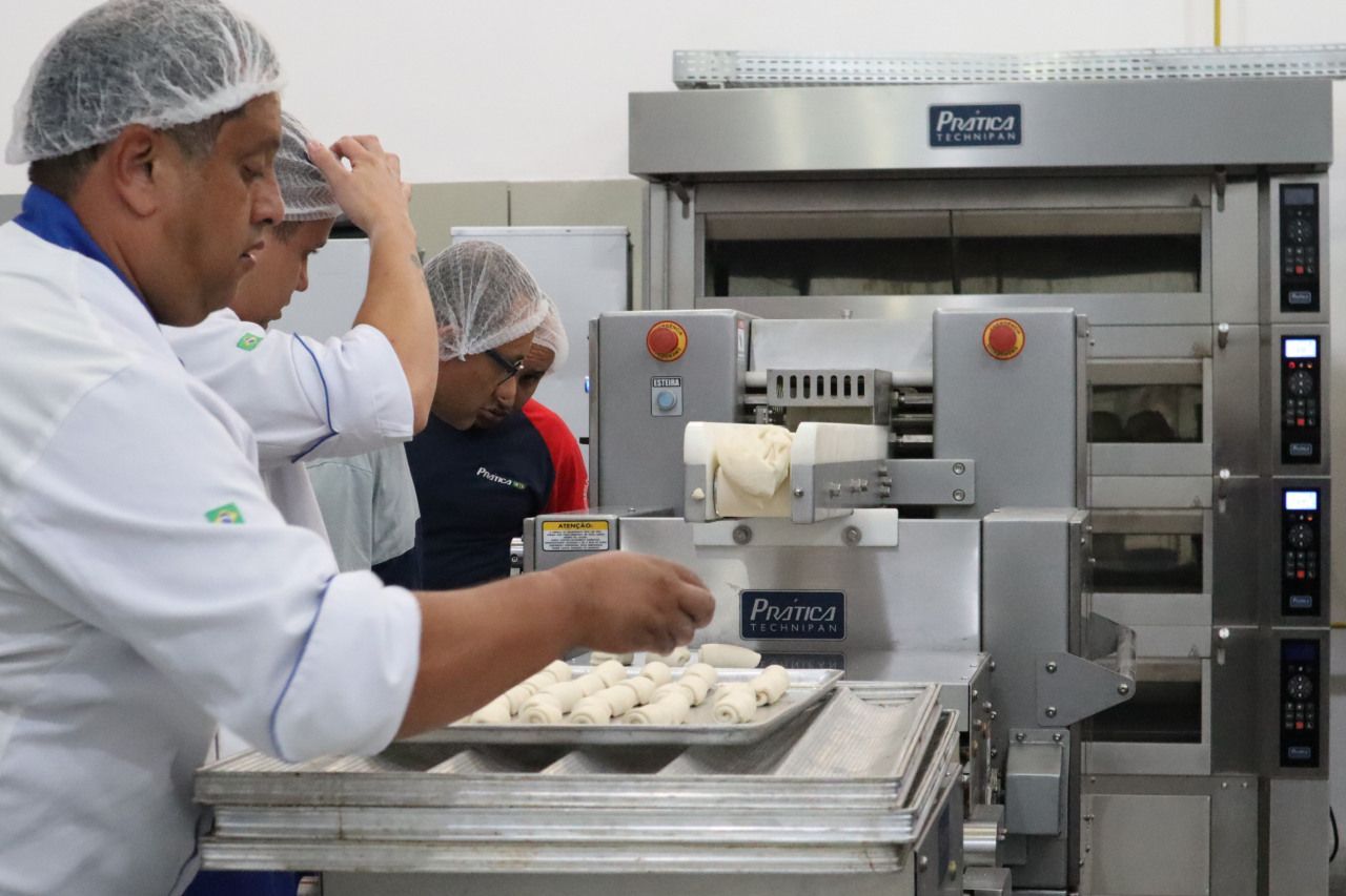 Um homem usando uma touca de plástico está trabalhando em uma cozinha