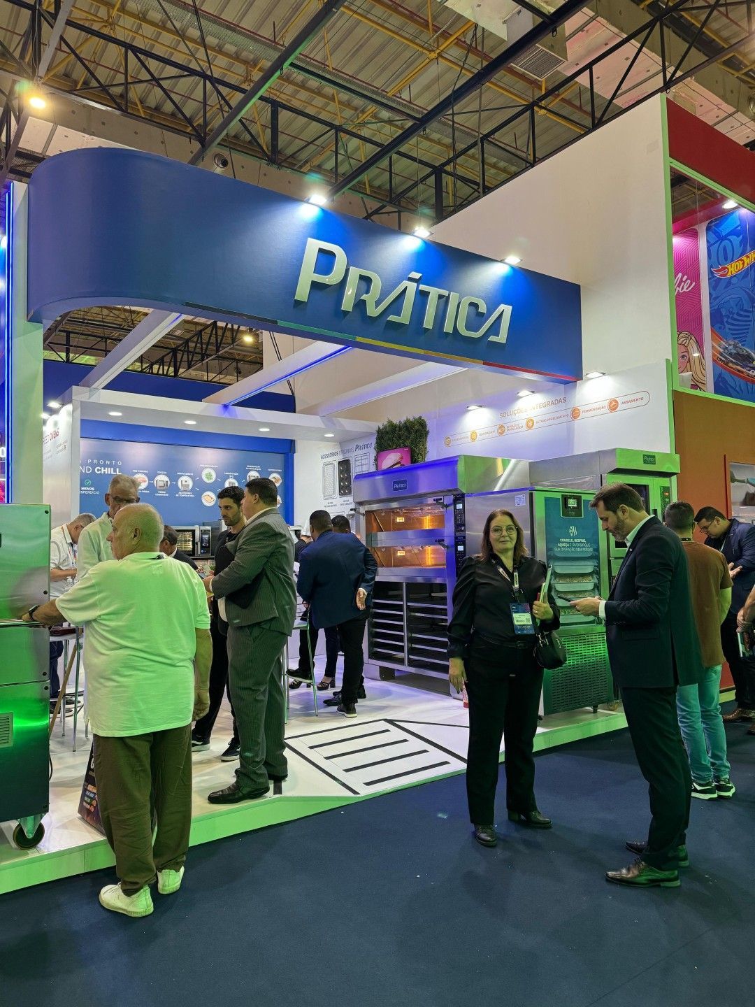 Um grupo de pessoas está em volta de um estande em uma convenção.