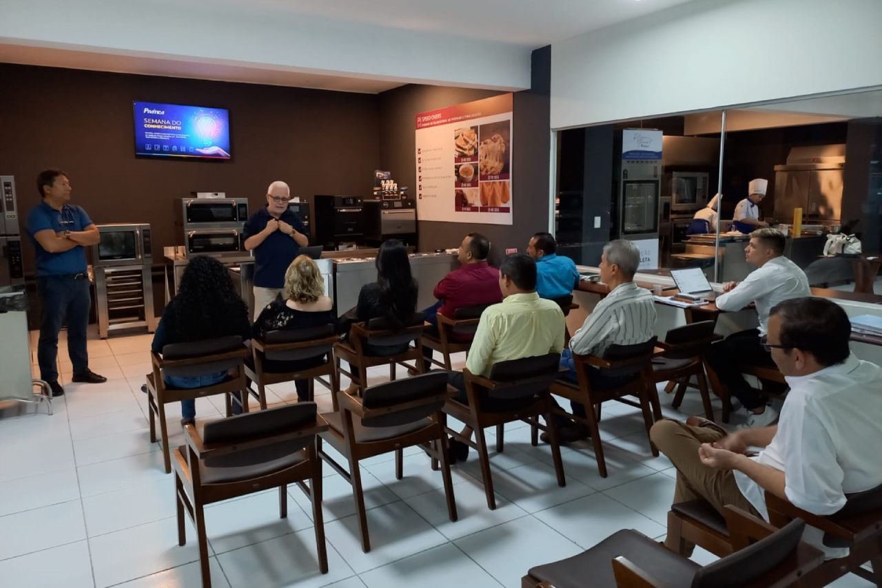 Um grupo de pessoas está sentado em cadeiras em uma sala