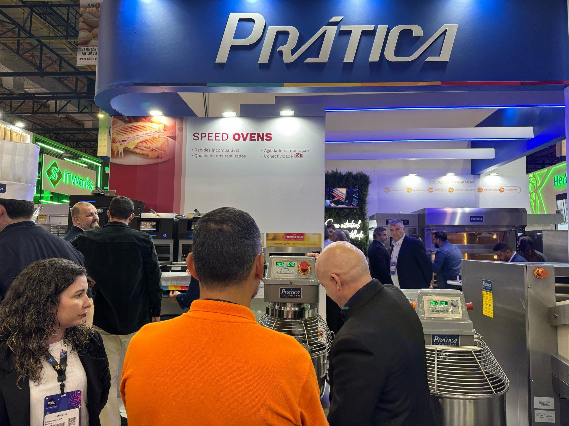 Um grupo de pessoas está em frente a uma placa de prática