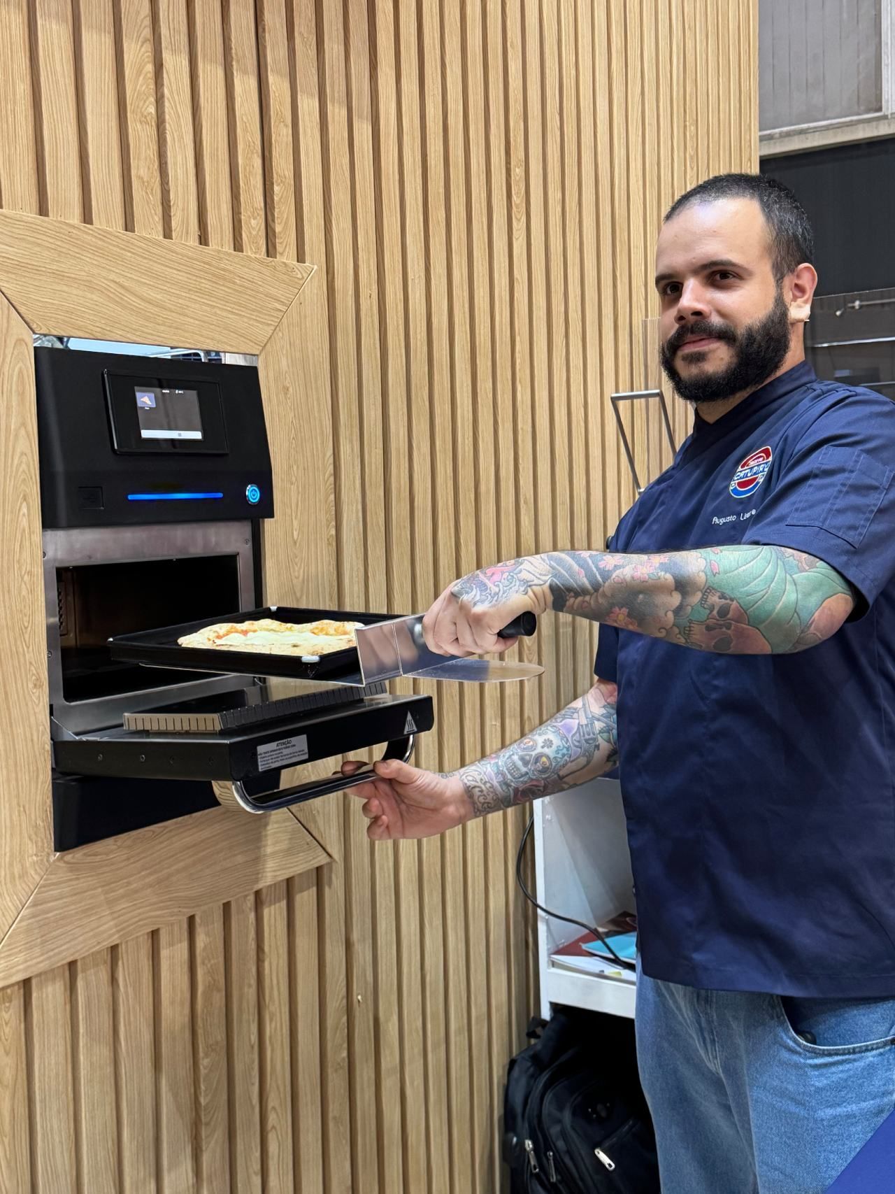 Um homem está tirando uma pizza do forno.