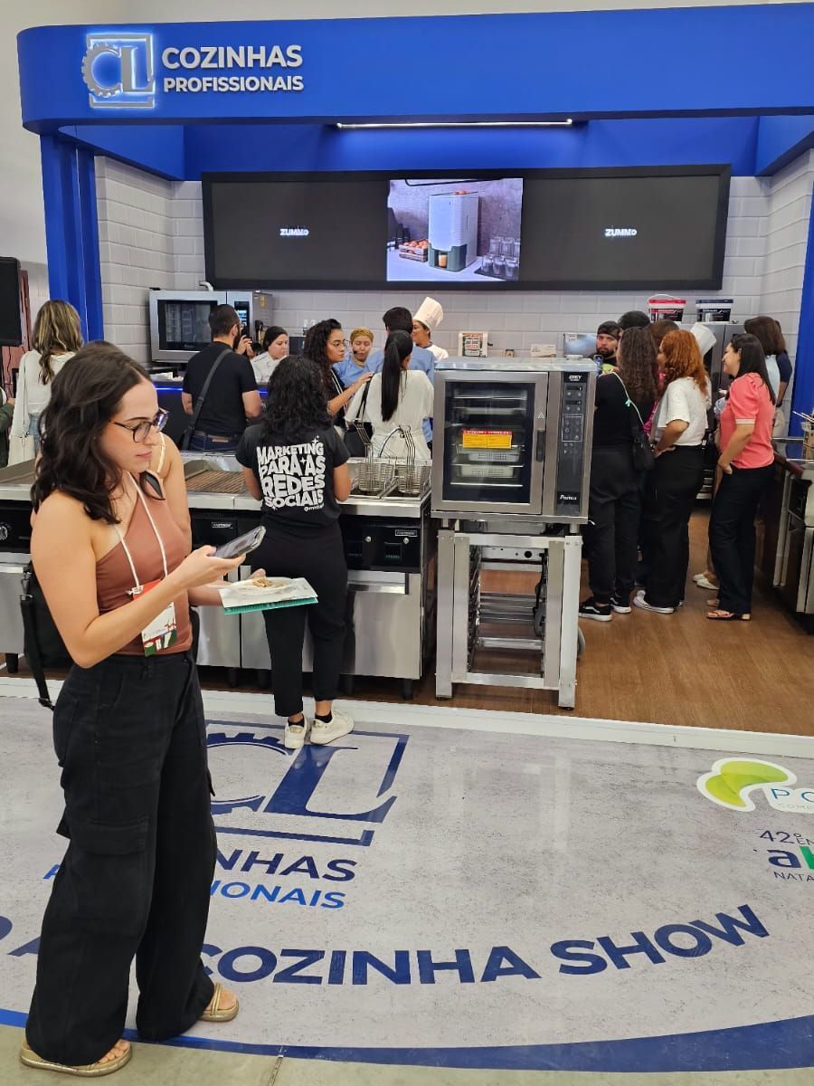 Uma mulher está parada em frente a um estande da cozinha show