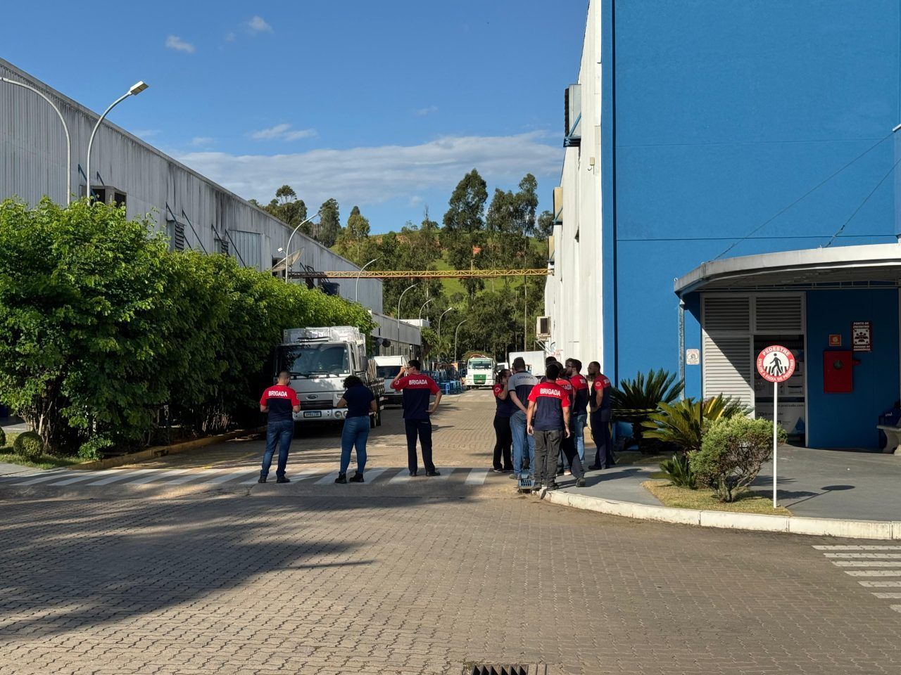 Um grupo de pessoas em pé em frente a um prédio azul
