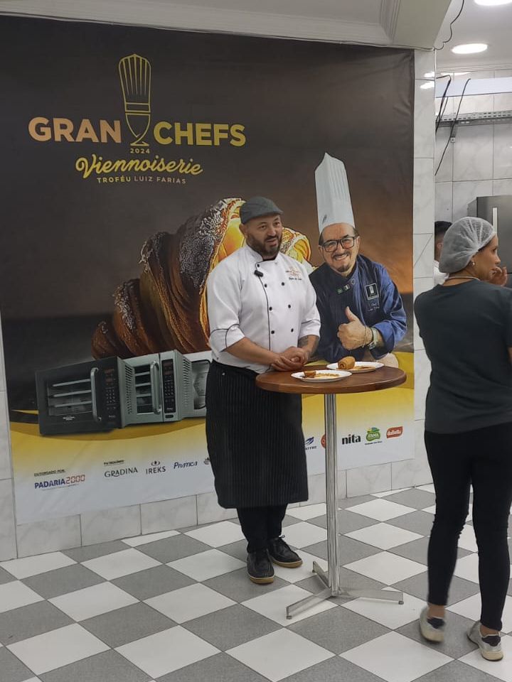 Dois chefs estão parados em frente a uma placa que diz gran chefs