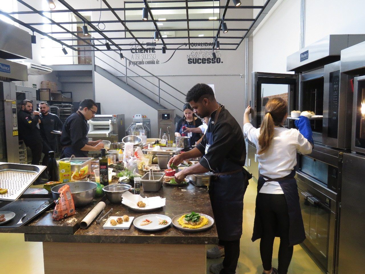 Um grupo de pessoas está preparando comida em uma cozinha.