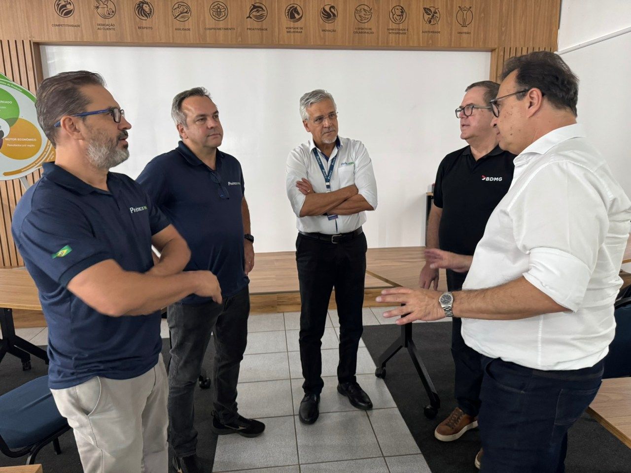 Um grupo de homens está em uma sala conversando entre si.