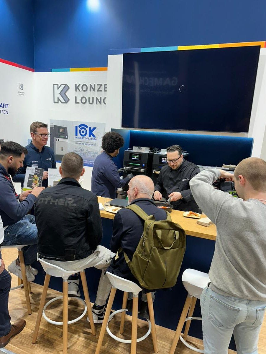 Um grupo de pessoas está sentado em mesas em uma sala.