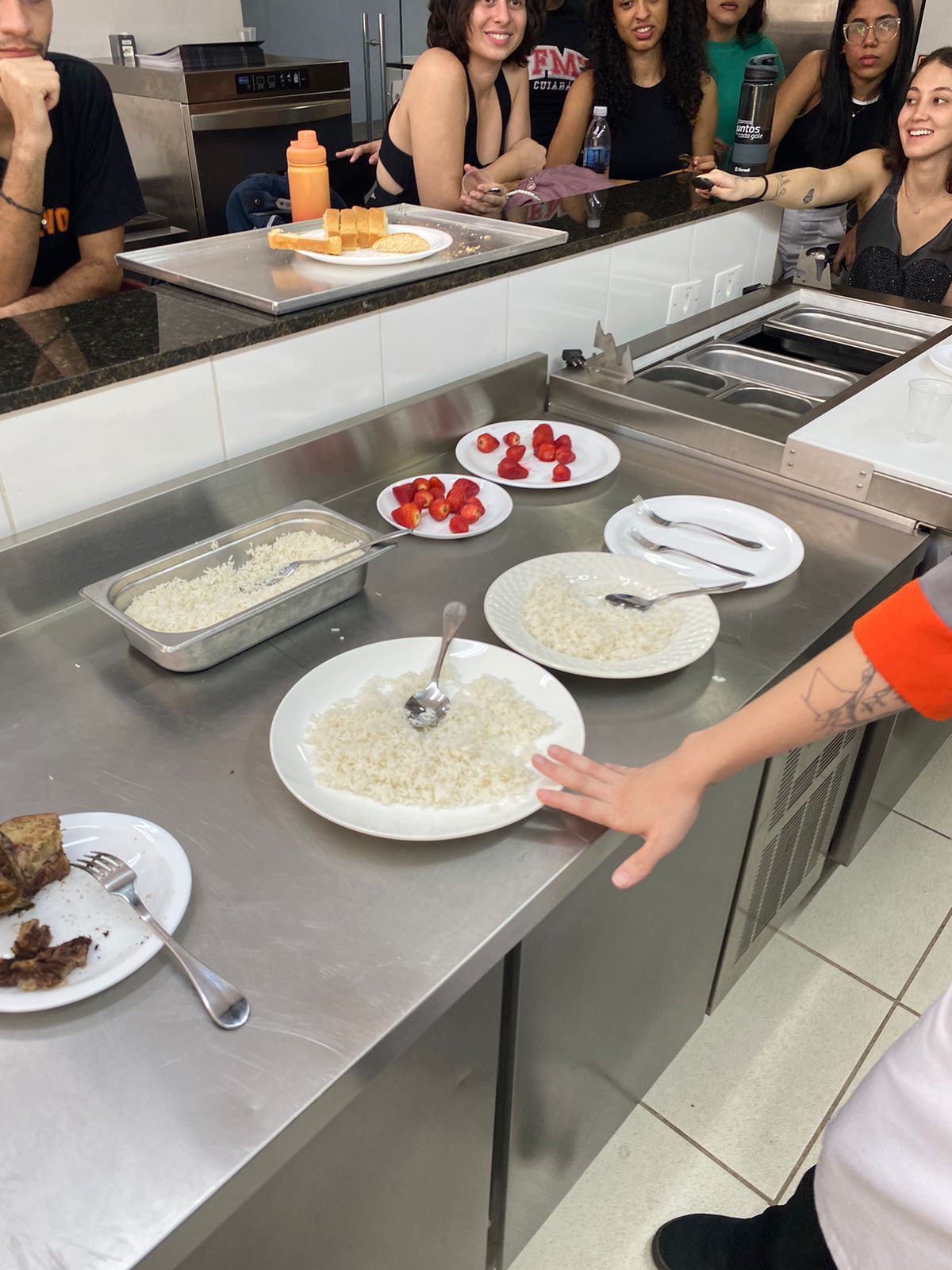 Um grupo de pessoas está sentado à mesa com pratos de comida.